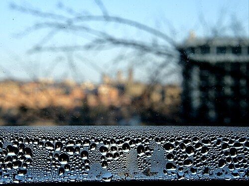 Gouttes de condensation sur une vitre et un appui de fenêtre en hiver