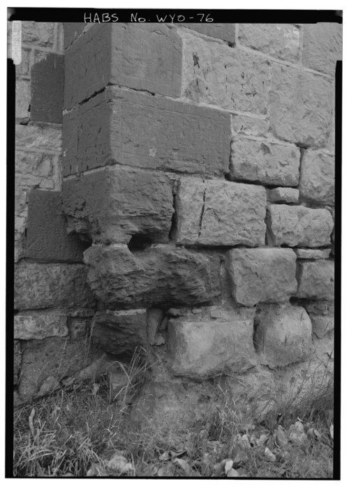 Pierres d'angle érodées en pied de mur par l'humidité qui remonte du sol